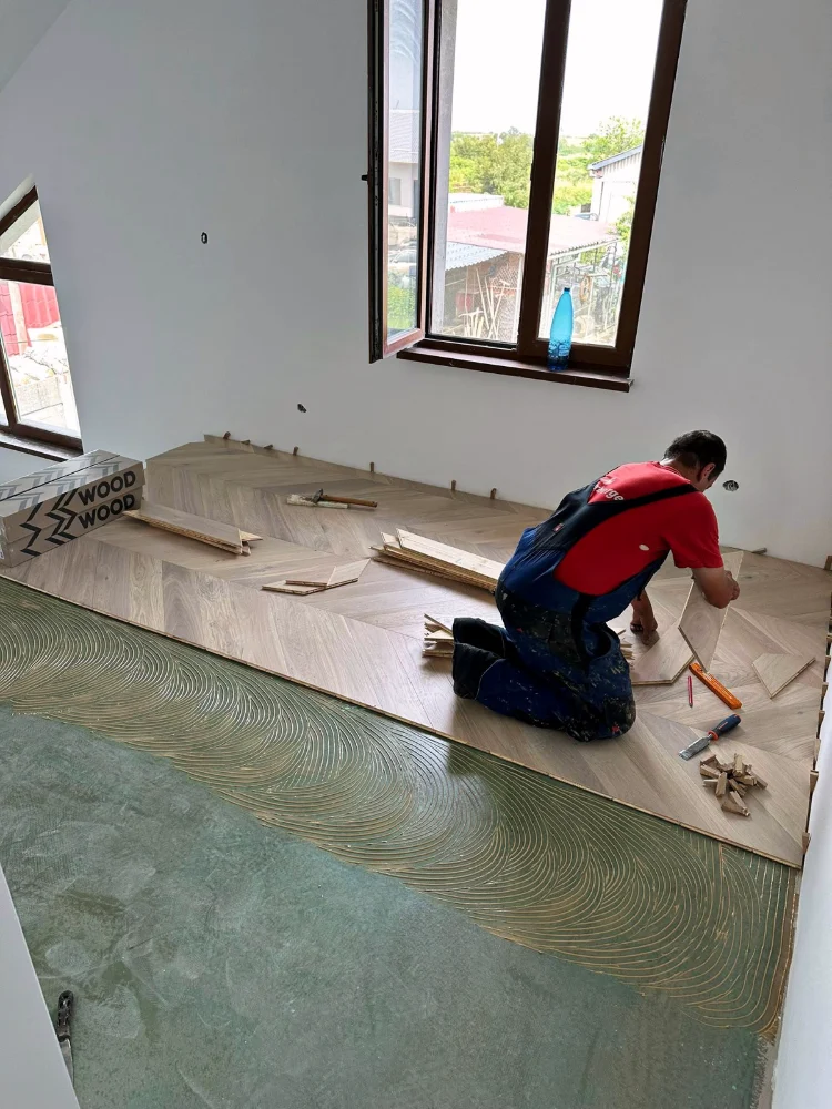 Installer laying engineered wood flooring over the underlay