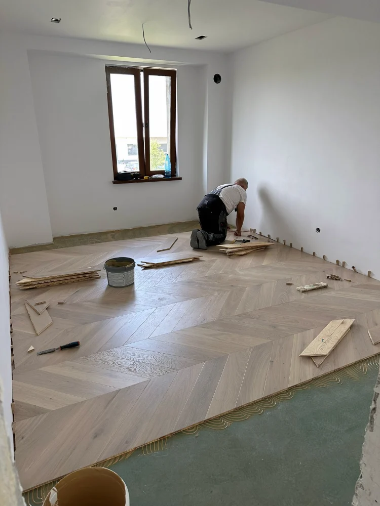 Engineered wood flooring in a herringbone pattern, during installation