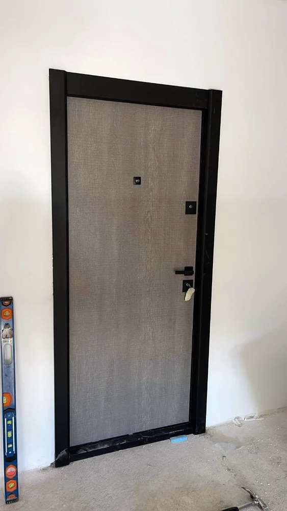 Apartment entrance door with a stone-effect finish and a black frame