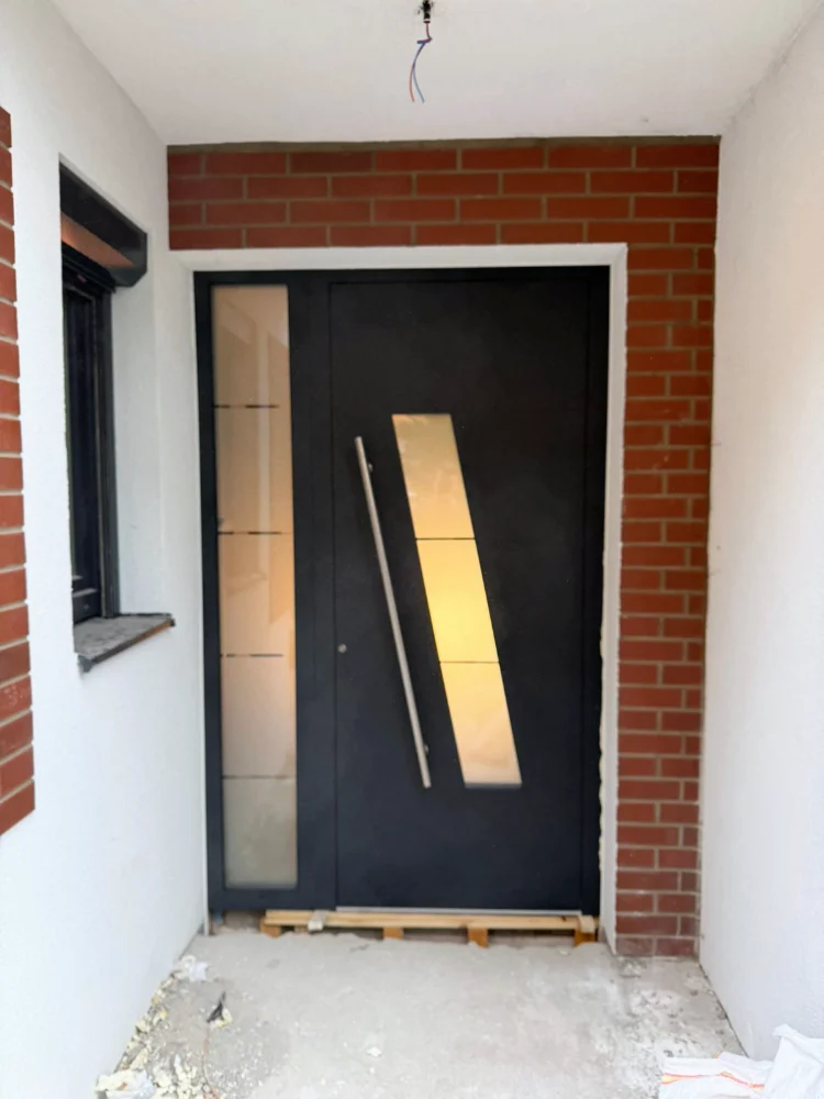 Anthracite entrance door with a diagonal glass insert and a side panel