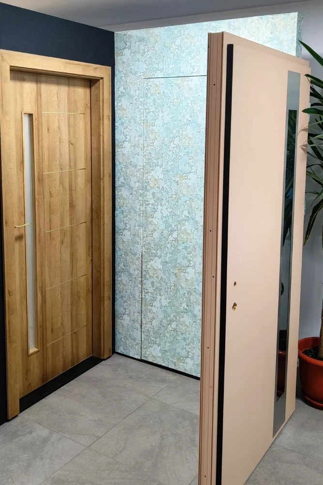 Door with a wood-effect finish and an open peach-pink door, in the same hallway