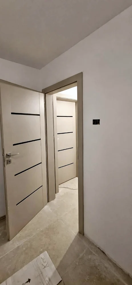 White interior door with black horizontal stripes, in a hallway