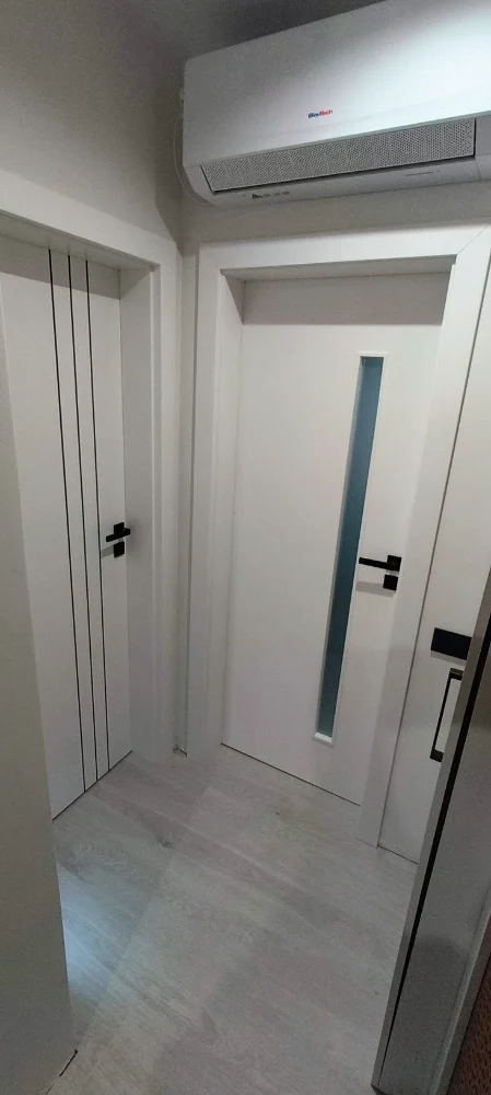 White interior doors, one with a vertical glass slot