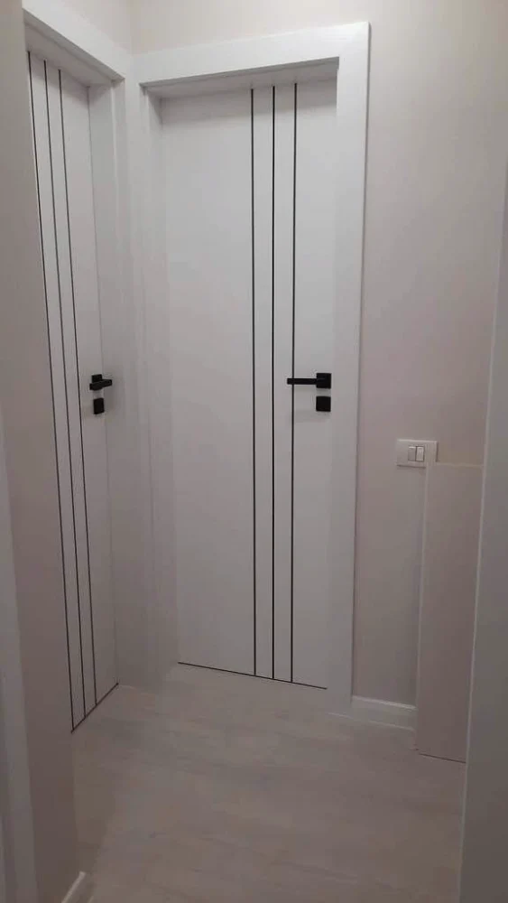 White interior doors with black vertical lines and black handles
