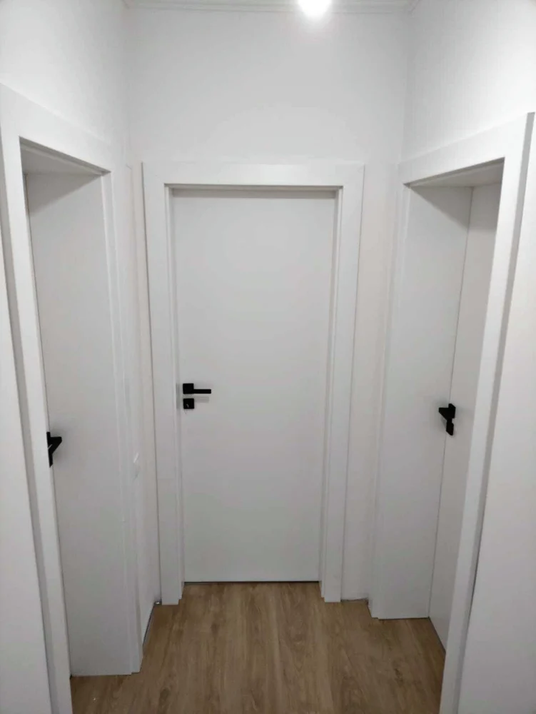White interior doors with black handles, in a hallway