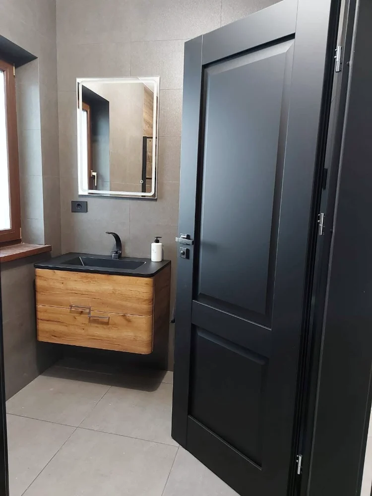 Classic black interior door, open to a bathroom with wooden furniture