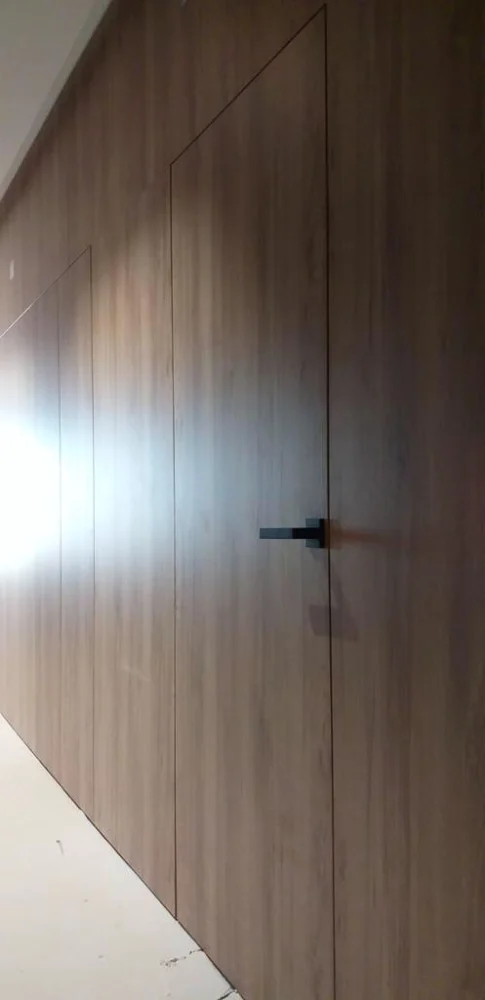 Wall clad in a wood-effect finish with a built-in Filomuro door