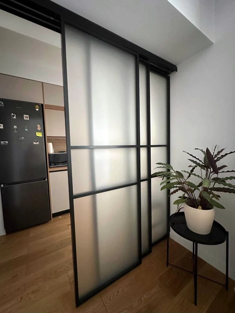 Sliding aluminium and frosted glass partition, next to the kitchen